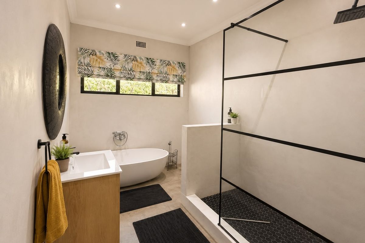 Modern bathroom featuring a sleek walk-in shower with black frame, a contemporary freestanding bathtub, and a stylish vanity unit.