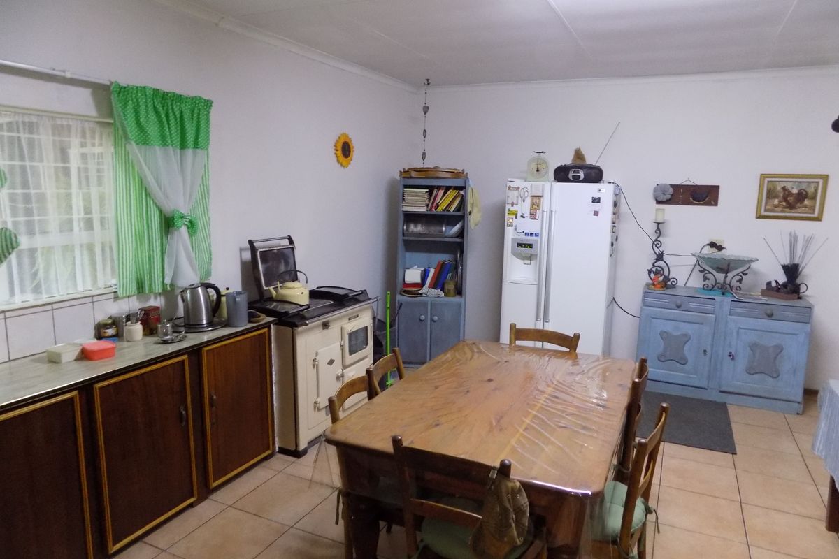 A dated kitchen area featuring tiled flooring, traditional cabinetry, and a vintage-style stove, offering significant potential for a modern renovation.