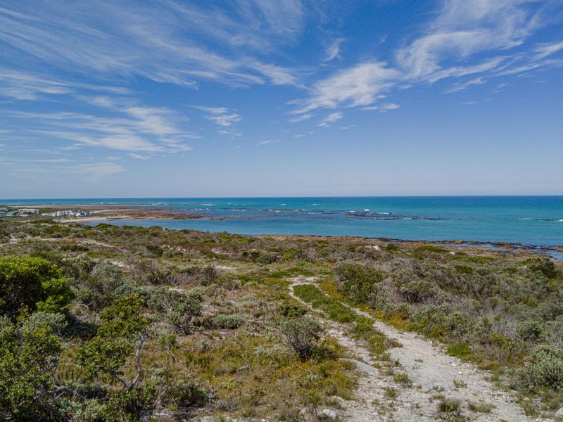 A scenic elevated view of the coastal landscape, featuring natural vegetation and direct access to the oceanfront.