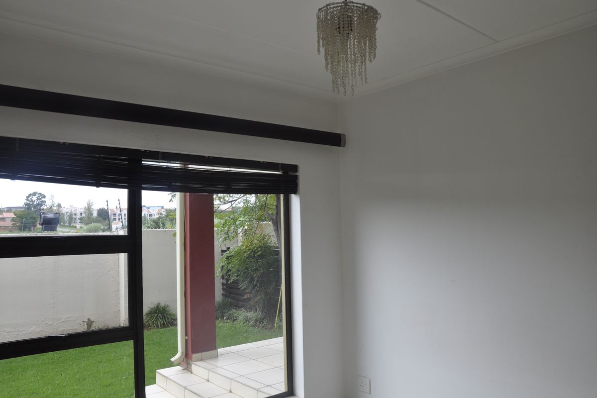 A bright living area featuring large sliding glass doors that open onto a private patio and garden space.