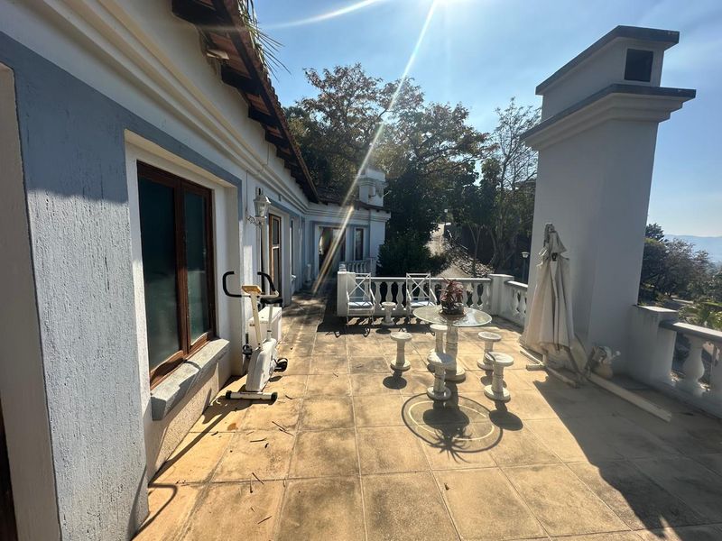 Spacious outdoor balcony featuring tiled flooring and a classic balustrade, offering an ideal area for relaxation and outdoor living.