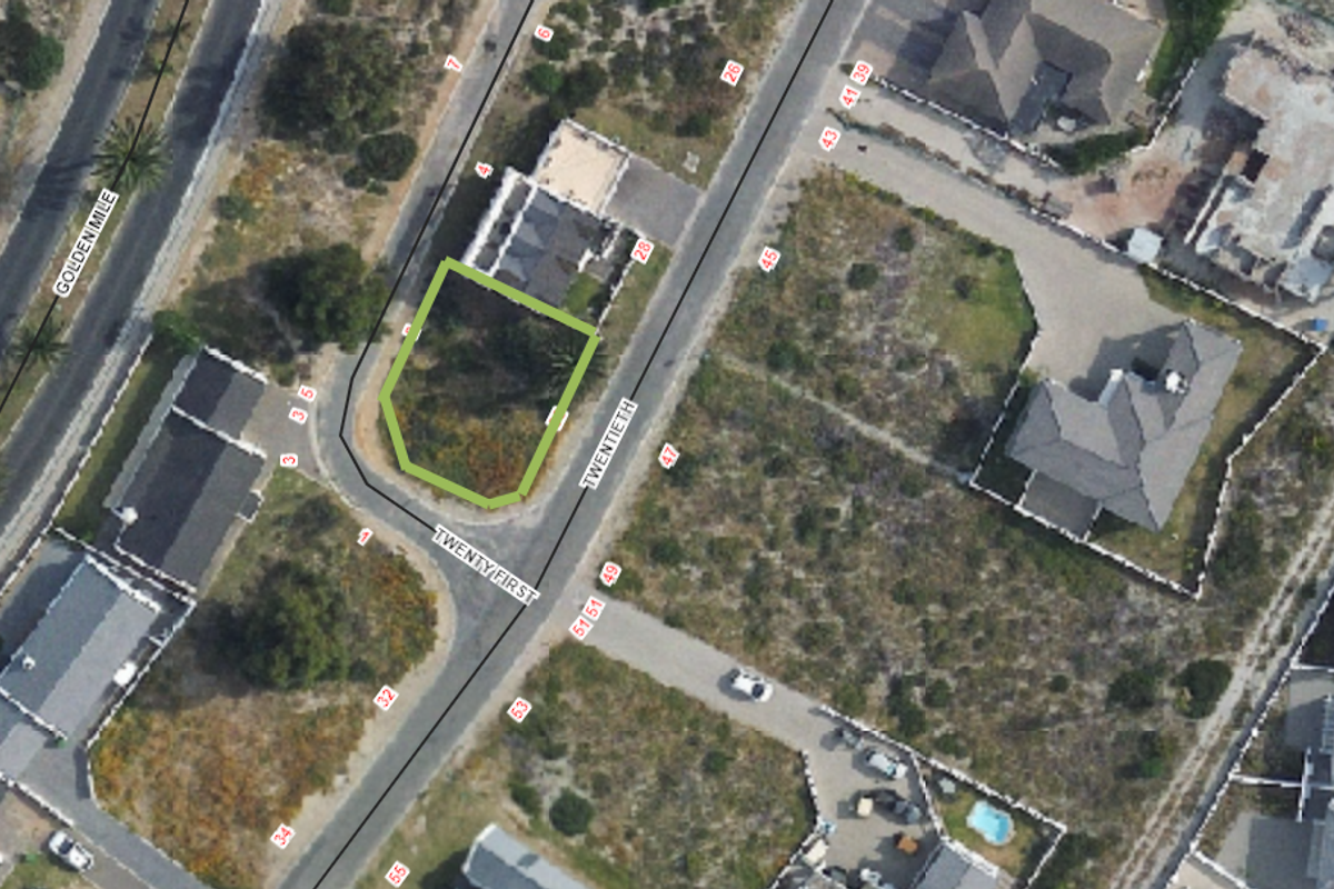 Aerial view of a vacant residential corner plot situated at the intersection of two streets in a developed neighborhood.