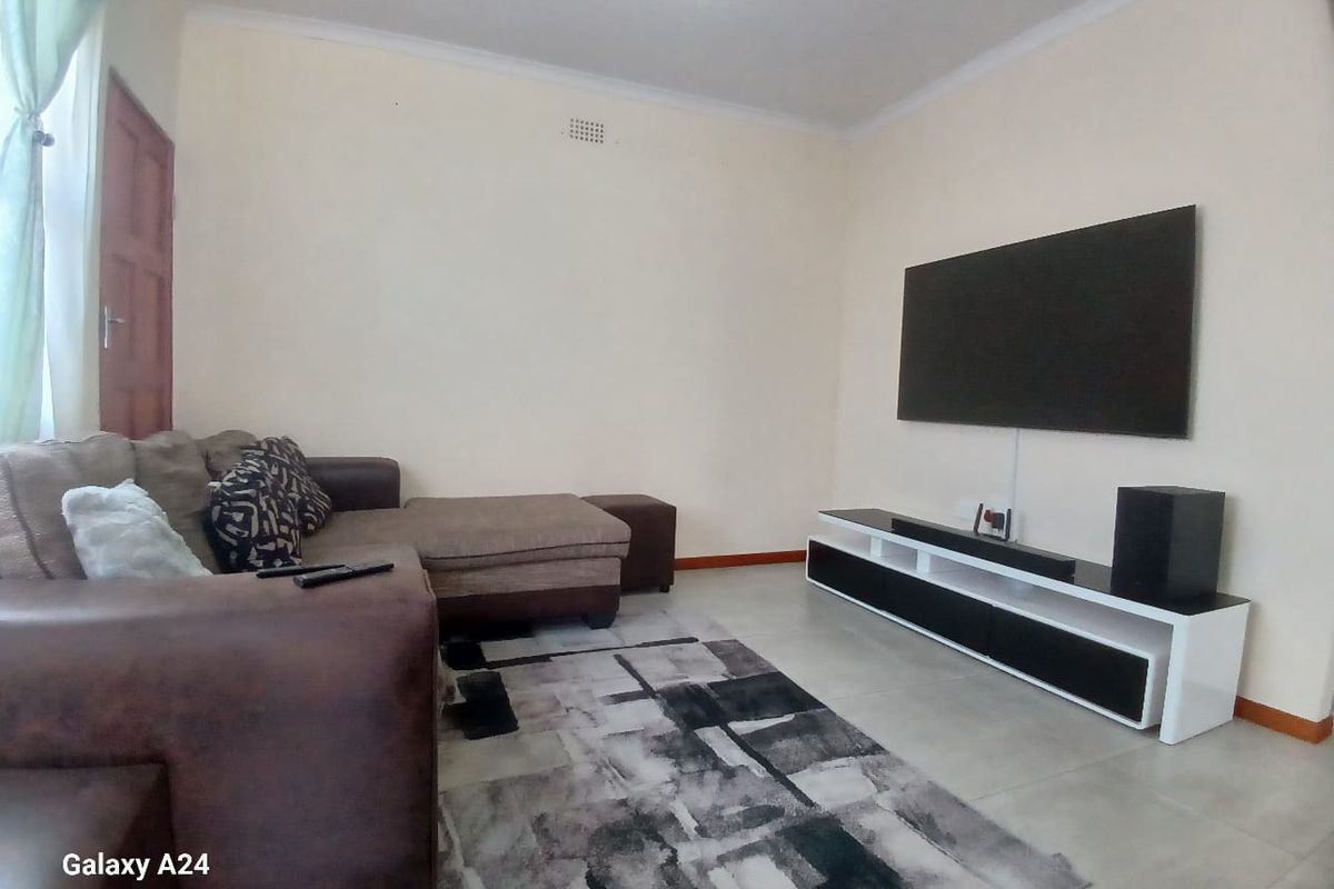 A living room featuring tiled flooring and coved ceilings, providing a neutral base for interior design updates.