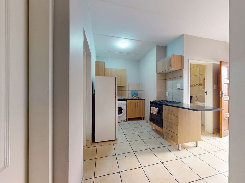 Functional kitchen featuring built-in cabinetry, tiled flooring, and integrated cooking appliances, offering a practical layout for daily meal preparation.