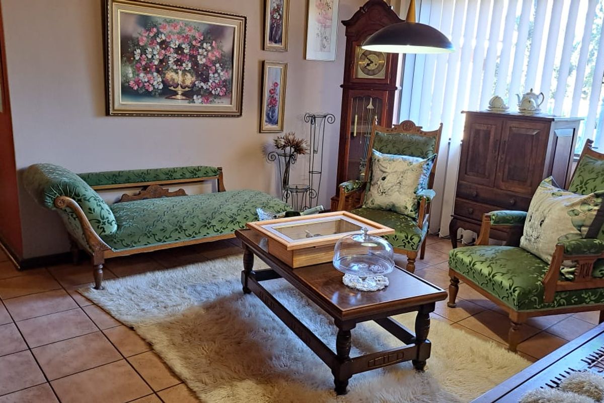 A traditional living room featuring ceramic floor tiles and vertical window blinds, offering a classic and well-maintained interior space.