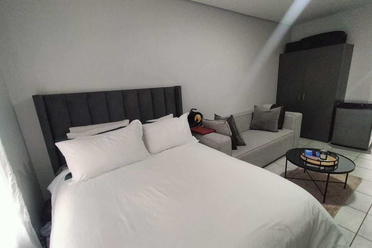 A bedroom featuring tiled flooring and a built-in wardrobe, providing a functional living space.