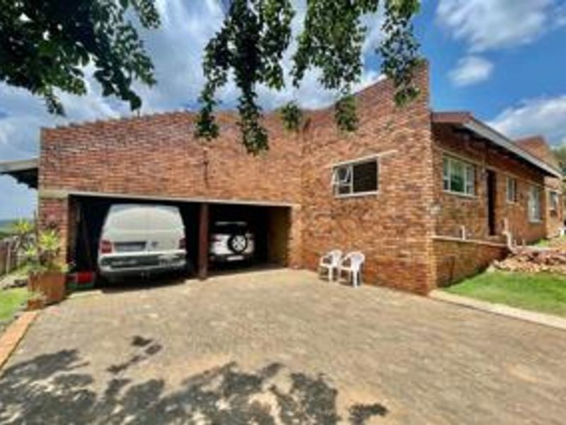 Front exterior view of a face brick house featuring a double garage and a paved driveway.