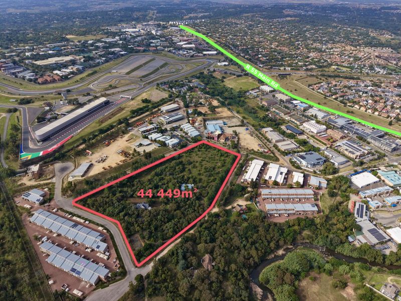 Aerial view of a large 44,449 square meter vacant residential land parcel situated in a developed area near major roads and commercial facilities.