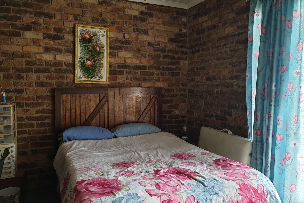 A bedroom featuring rustic exposed brick walls, providing a textured backdrop for the sleeping area.