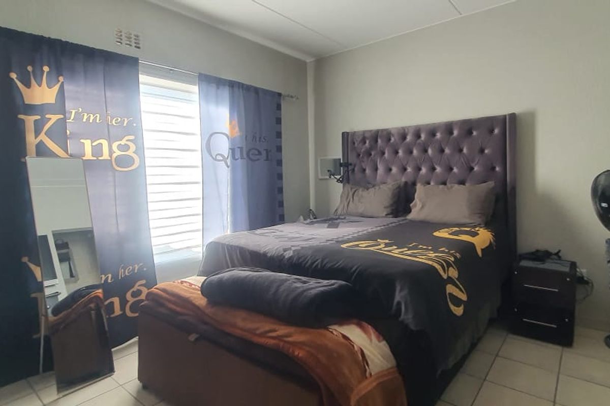 A bedroom featuring tiled flooring and a window with curtain tracks, providing a functional space for rest.