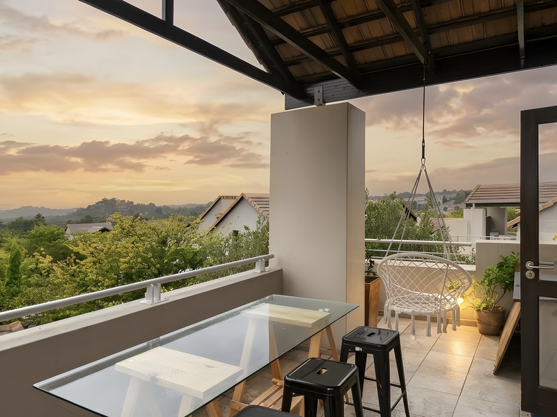 A covered balcony featuring tiled flooring, a metal balustrade, and scenic elevated views of the surrounding landscape.