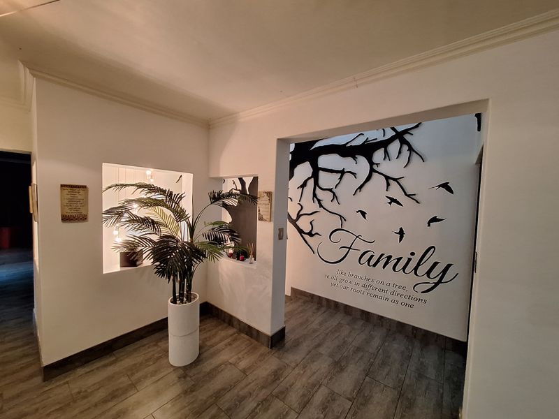 An inviting entryway featuring wood-look tile flooring, coved ceiling cornicing, and decorative recessed wall niches.