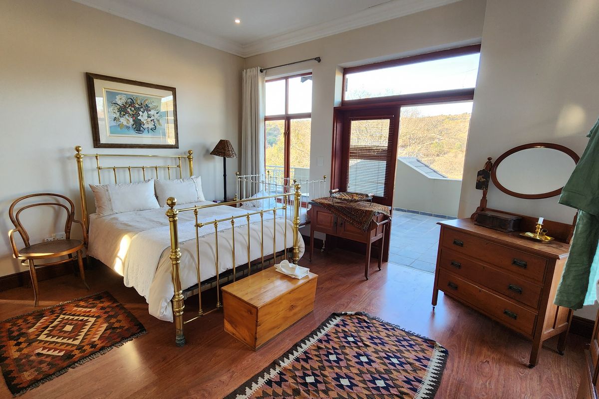 Spacious bedroom featuring laminate flooring, recessed lighting, and direct access to a private balcony through large glass doors.