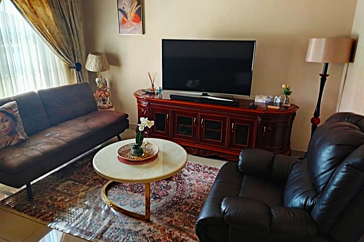 A comfortable living room featuring tiled flooring and neutral wall finishes, providing a functional space for relaxation and entertainment.