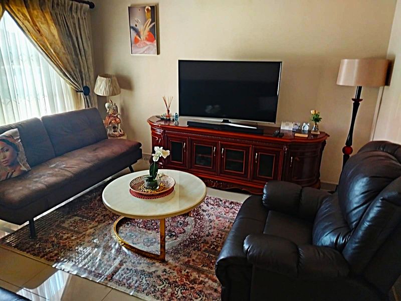 A comfortable living room featuring tiled flooring and neutral wall finishes, providing a functional space for relaxation and entertainment.