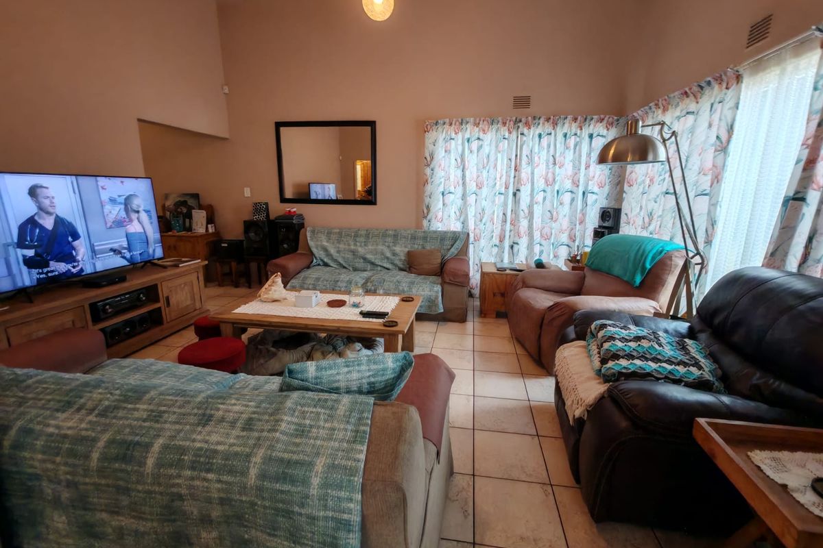 A spacious living room featuring high ceilings and tiled flooring, offering a comfortable and functional layout for relaxation.