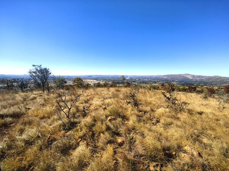A wide-angle view of the natural landscape and surrounding terrain, showcasing the expansive outlook from the vacant residential property.
