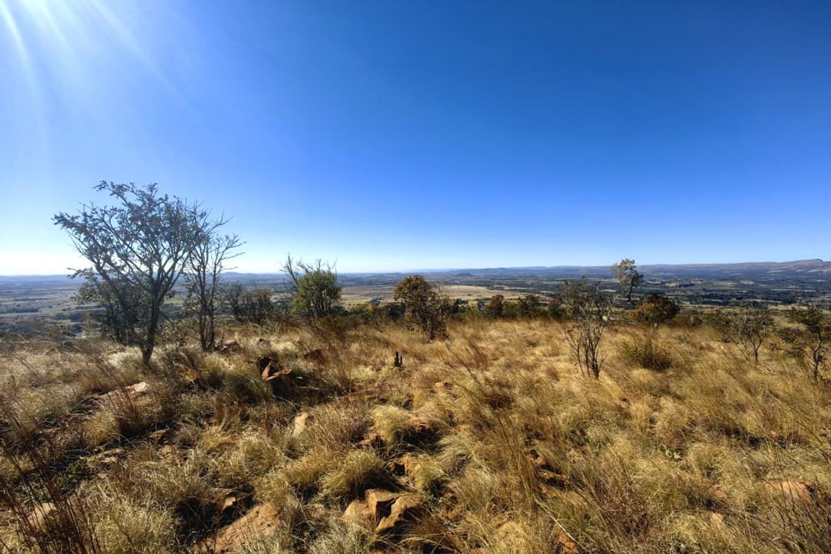 A wide-angle view of the natural landscape and rocky terrain on this vacant residential property.