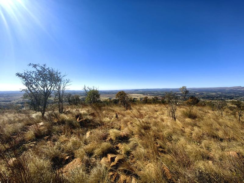 A wide-angle view of the natural landscape and rocky terrain on this vacant residential property.