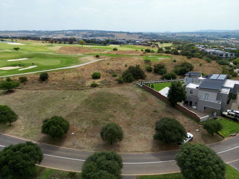 Aerial view of a vacant residential plot situated in a golf estate, featuring established landscaping and proximity to existing residential infrastructure.