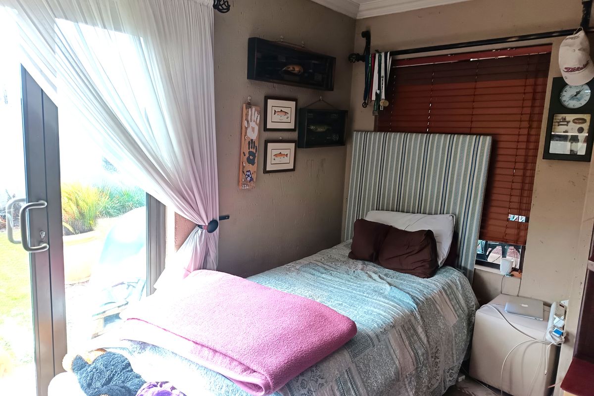 A cozy bedroom featuring a sliding glass door with access to the exterior, venetian blinds, and crown molding details.