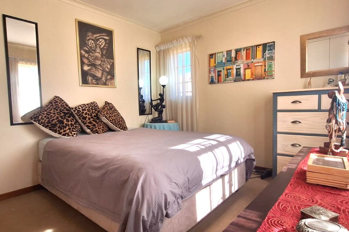 A standard bedroom featuring neutral wall finishes, coving, and natural light through a window.