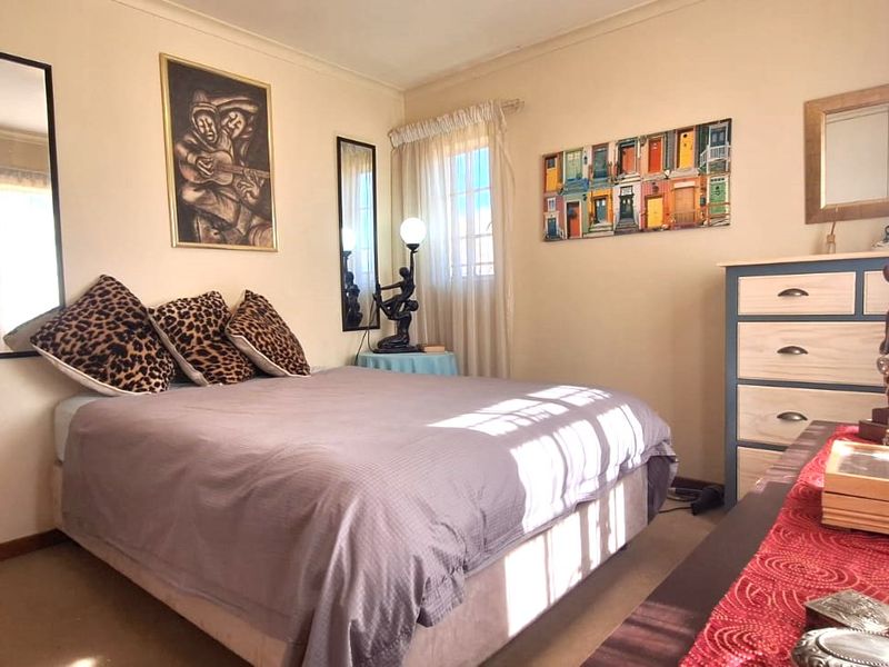 A standard bedroom featuring neutral wall finishes, coving, and natural light through a window.