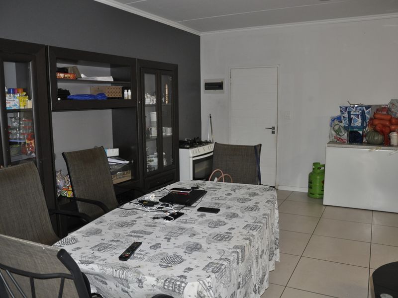 Open plan living and dining area featuring tiled flooring and a built-in gas stove, offering a functional layout for daily living.