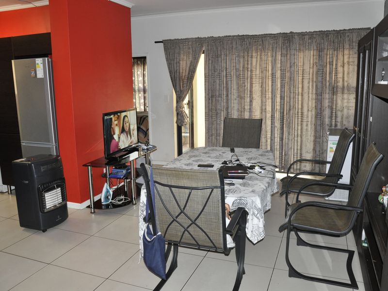 Open plan living and dining area featuring tiled flooring and direct access to an outdoor space through a sliding door.