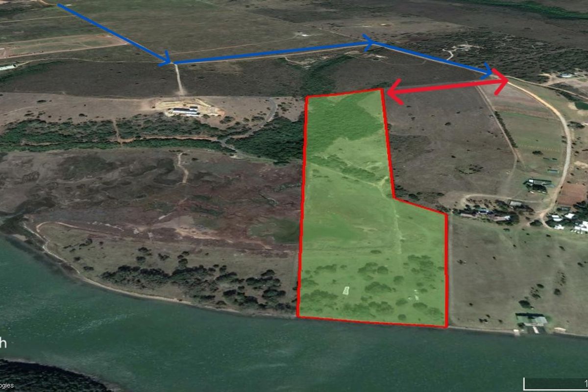 Aerial view of a large, vacant residential plot featuring direct waterfront access and natural landscape, ideal for development.