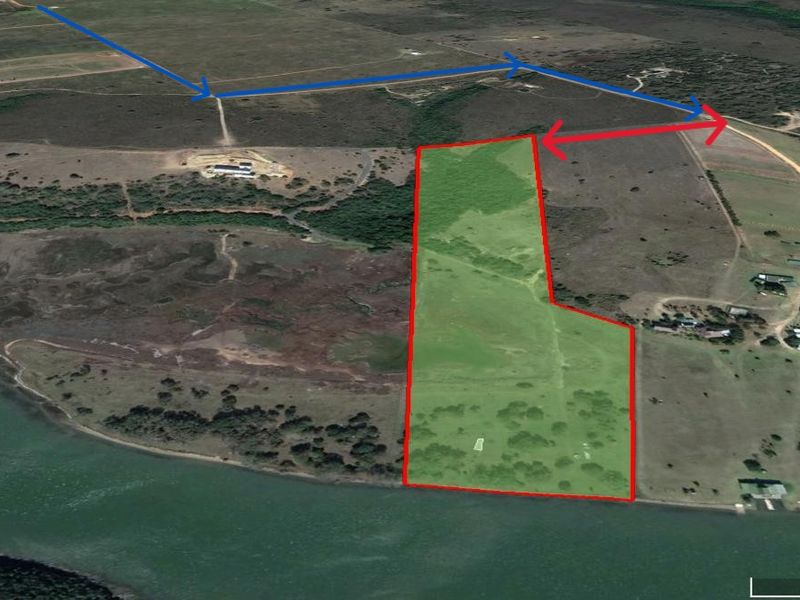 Aerial view of a large, vacant residential plot featuring direct waterfront access and natural landscape, ideal for development.