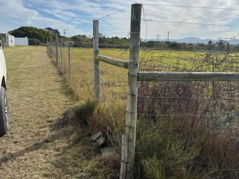 A view of the residential vacant land boundary featuring wire fencing and timber posts, with surrounding natural landscape.