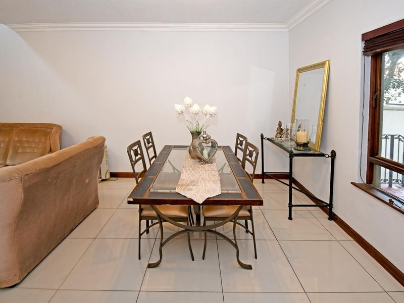 A dining area featuring tiled flooring, crown molding, and a timber-framed window, providing a functional space for meals.