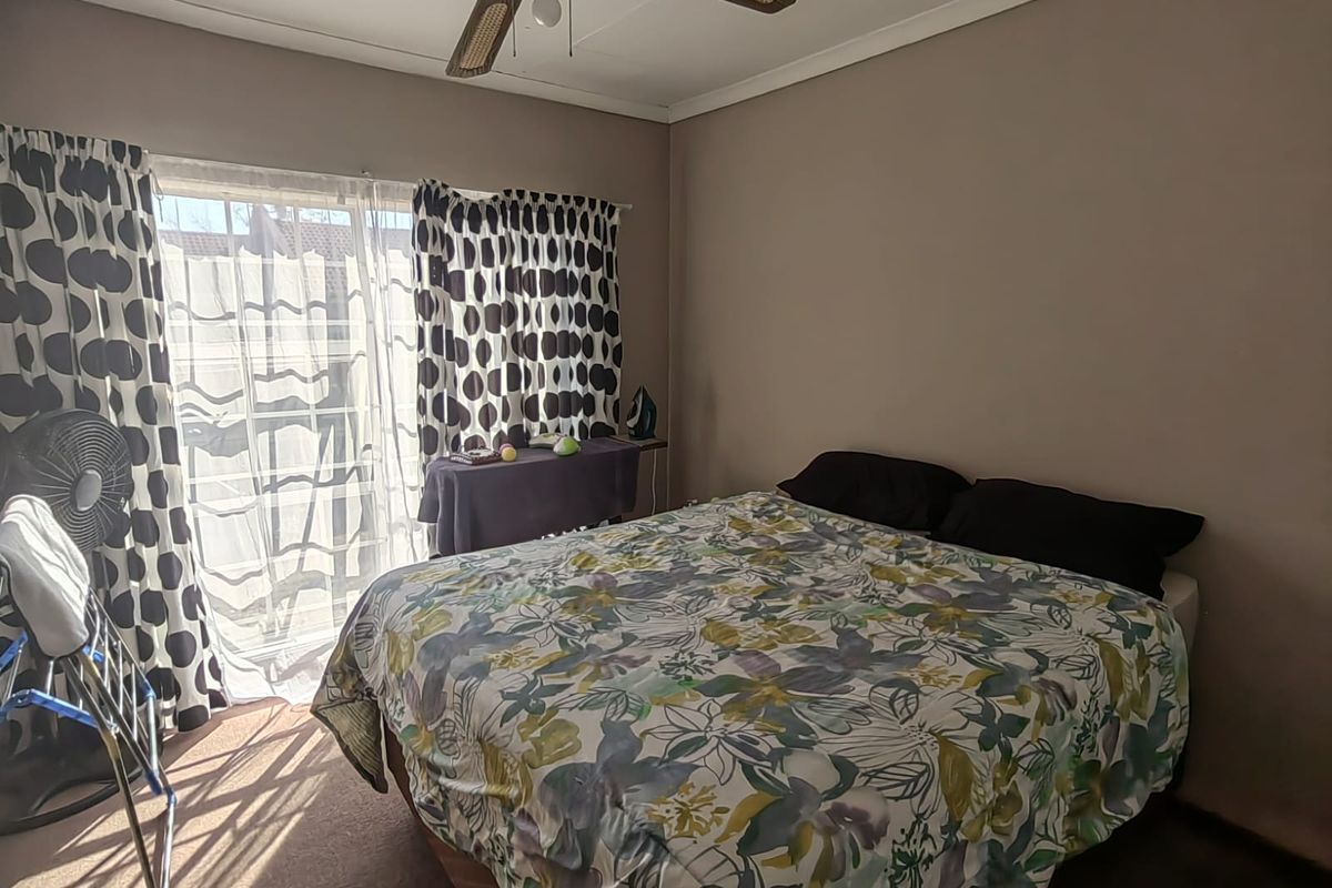 A bedroom featuring carpeted flooring, a ceiling fan, and a sliding glass door providing access to the exterior.
