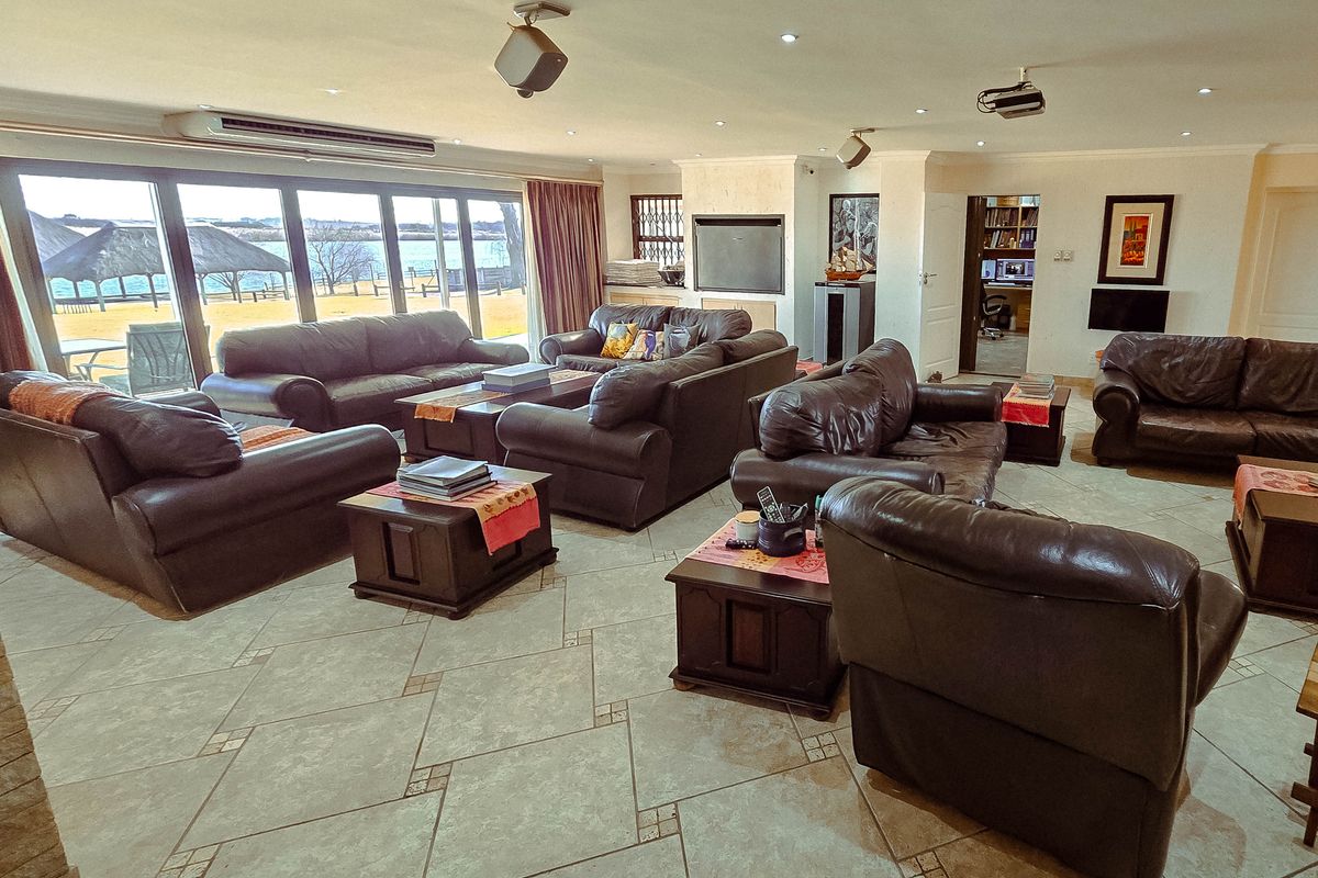 Spacious open-plan living area featuring large sliding glass doors with scenic views, tiled flooring, and a built-in fireplace.