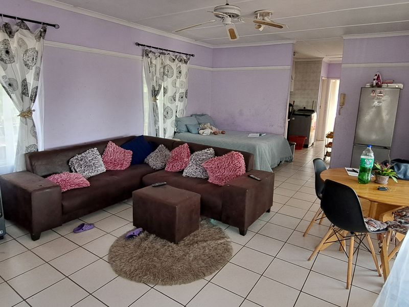Open-plan living and sleeping area featuring tiled flooring and a ceiling fan, with a neutral layout ready for modernization.