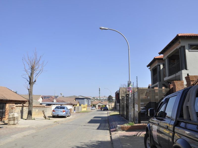 A view of the residential street showing the surrounding neighborhood context and access to the property.