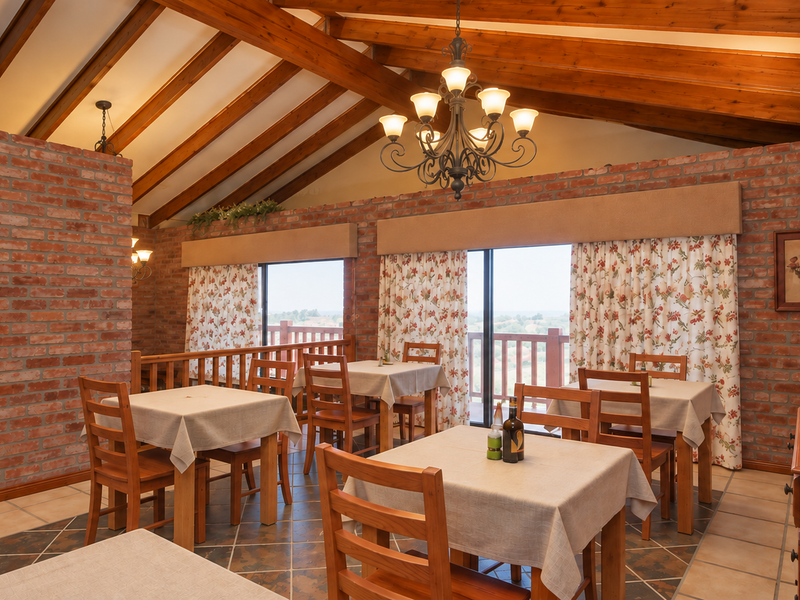 Spacious dining area featuring exposed brick walls, vaulted timber ceilings, and large sliding doors that provide natural light and access to the outdoors.