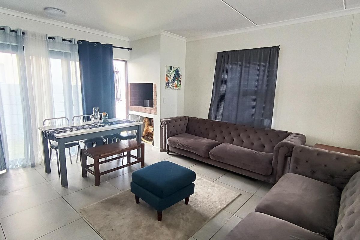 Open-plan living area featuring tiled flooring, a built-in fireplace, and sliding glass doors providing access to the outdoor space.