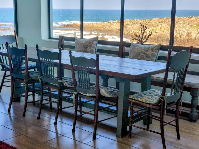 A dining area featuring large floor-to-ceiling windows that provide expansive ocean views and natural light.