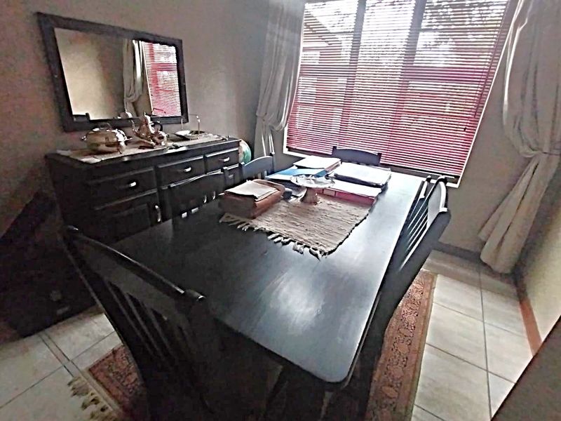 A dining room featuring tiled flooring and venetian blinds, providing a functional space for meals.