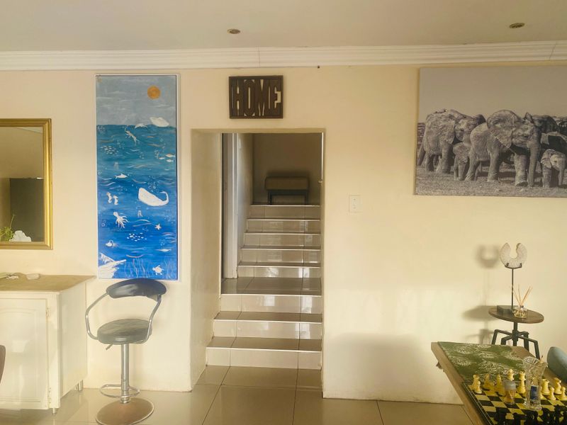 A view of a tiled staircase leading to an upper level, featuring neutral wall finishes and recessed ceiling lighting.