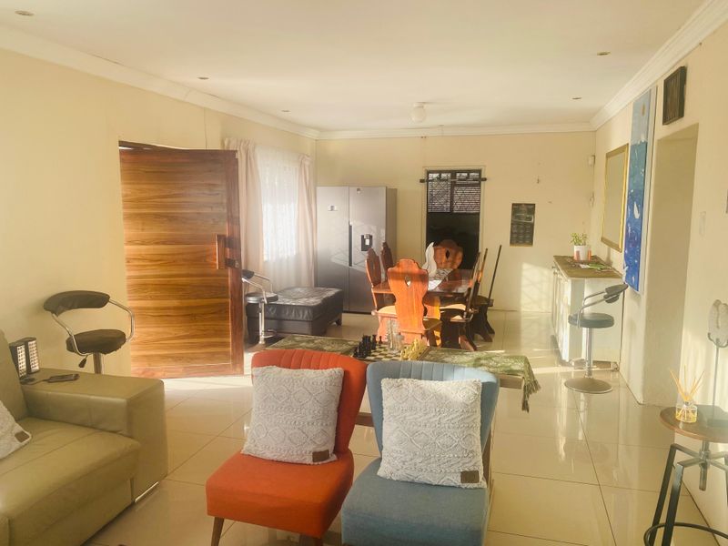 Spacious open-plan living and dining area featuring tiled flooring, recessed lighting, and coved cornicing, offering a bright and versatile layout.