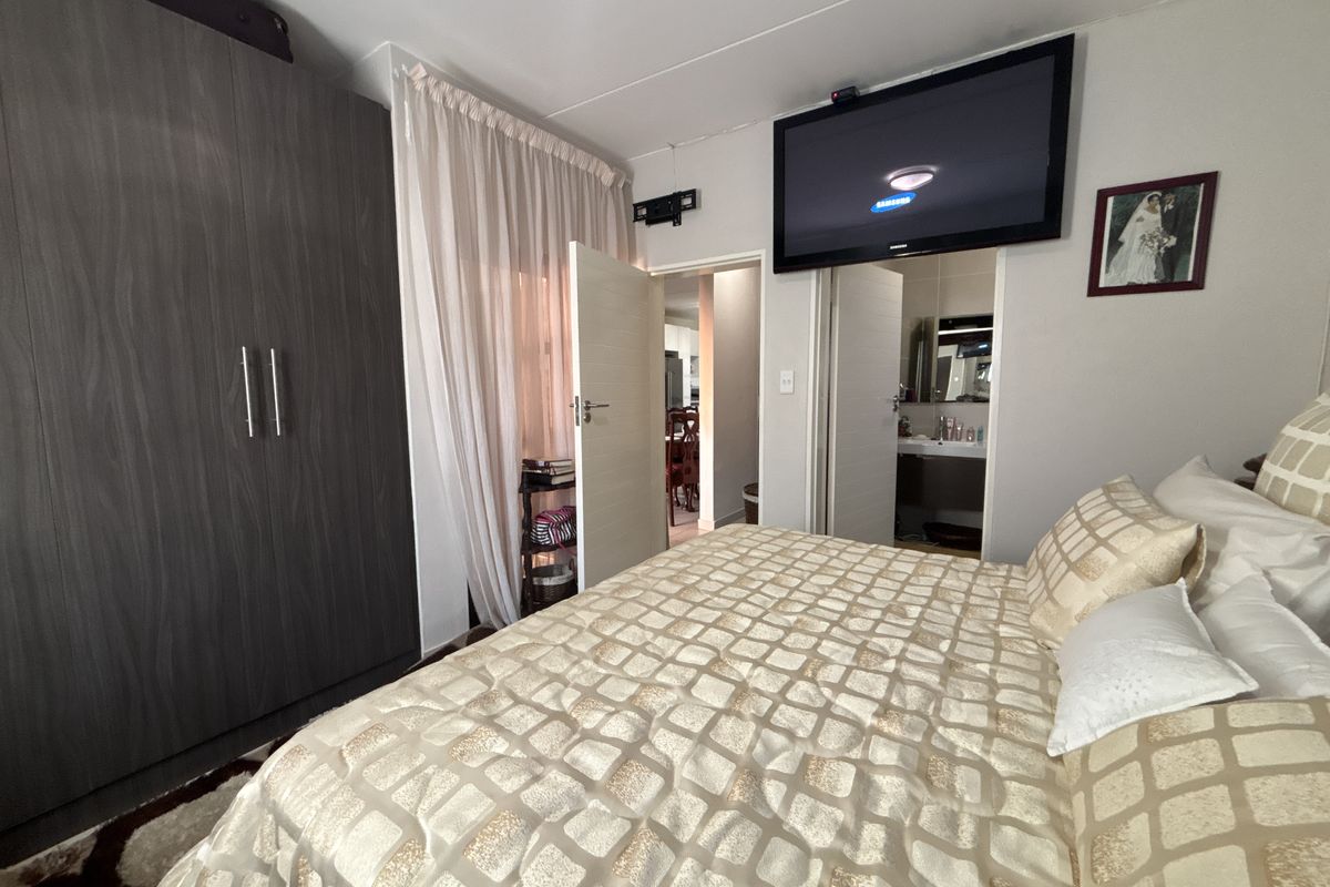 A bedroom featuring a large built-in wardrobe and direct access to an en-suite bathroom.