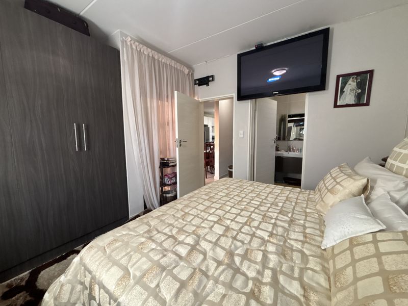 A bedroom featuring a large built-in wardrobe and direct access to an en-suite bathroom.