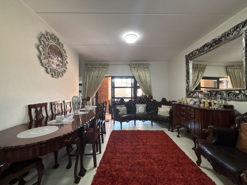 Open-plan living and dining area featuring tiled flooring and a sliding glass door leading to an outdoor space.