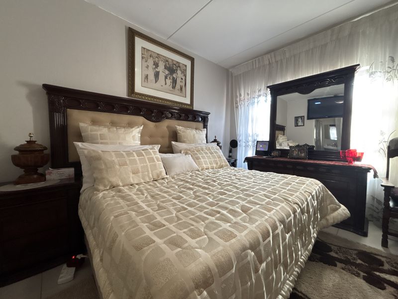 A well-maintained bedroom featuring tiled flooring and neutral wall finishes, offering a comfortable and functional living space.