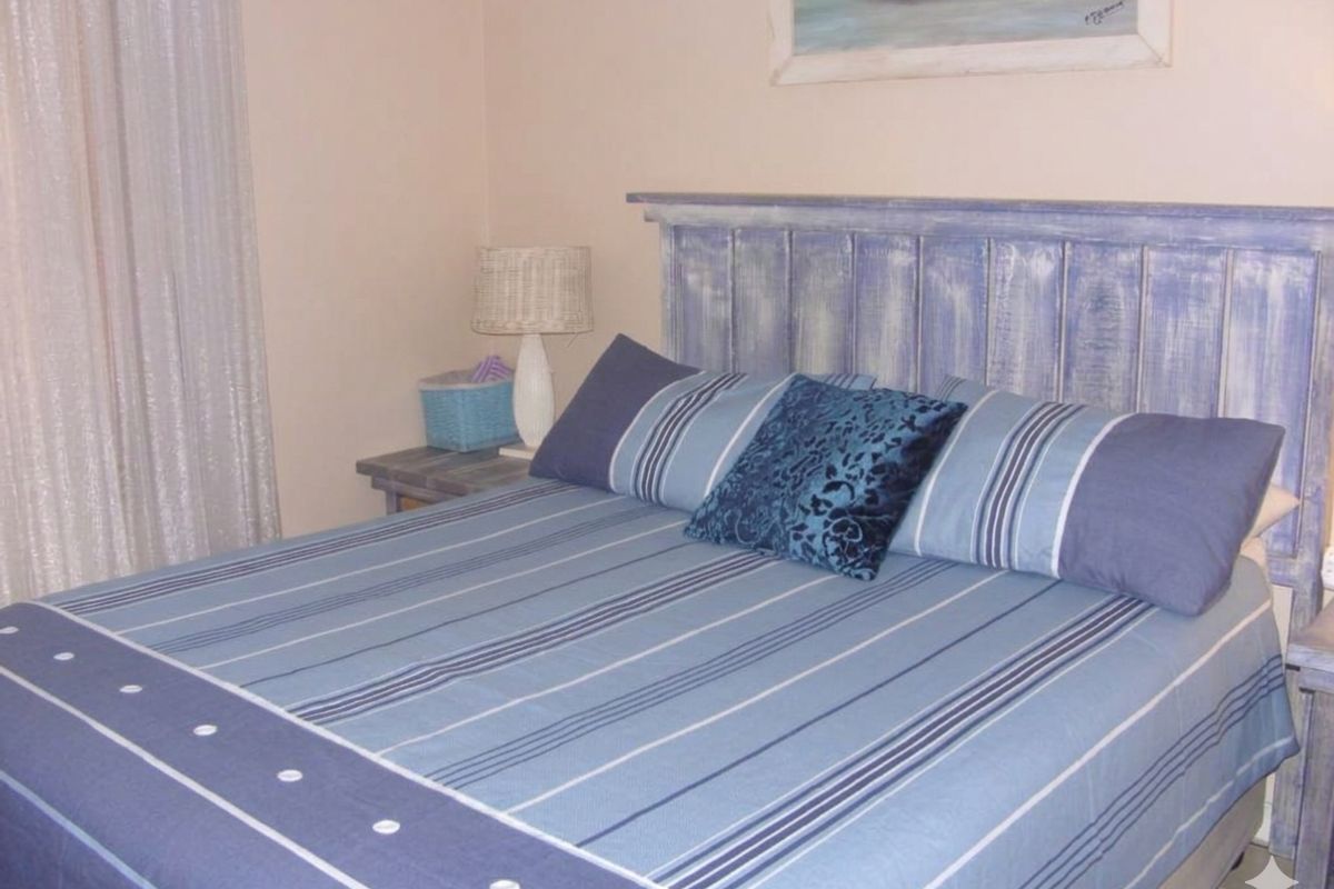 A cozy bedroom featuring a rustic blue wooden headboard and neutral wall finishes.