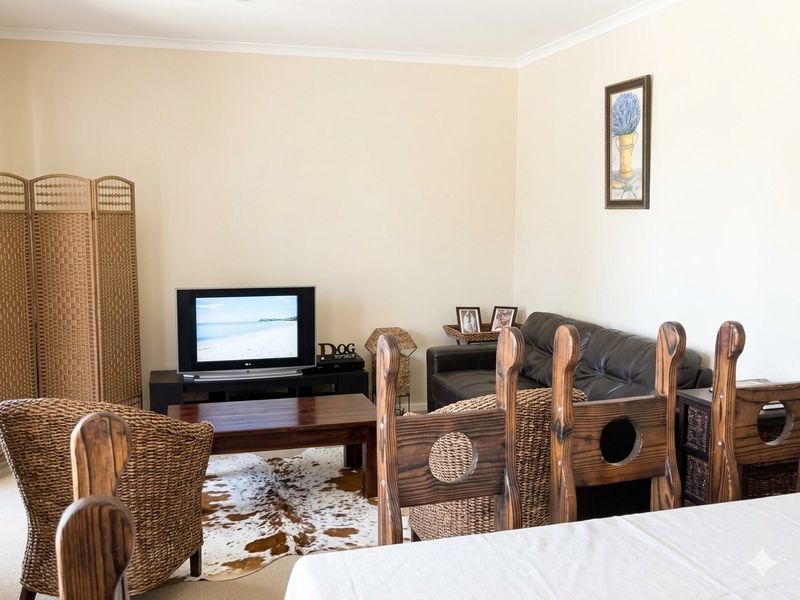 A comfortable living room area with neutral wall finishes, providing a functional space for relaxation and entertainment.