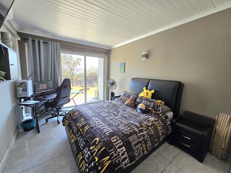 A bedroom featuring tiled flooring, a tongue and groove ceiling, and a sliding glass door providing access to the outdoors.